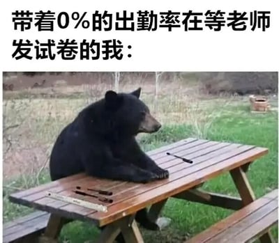 这是一张图文混排的搞笑梗图，画面上方配有简体中文文字“带着0%的出勤率在等老师发试卷的我：”，下方是一张原始拍摄的户外照片：一只黑熊前爪搭在木质野餐桌上，身体坐直，侧头看向画面一侧，桌上还摆放着类似笔、尺子的物品，模拟出学生坐在课桌前的姿态。这张图通过将黑熊拟人化，用夸张的反差感来调侃那种一学期完全没有出勤，却依然等待考试发卷的学生，精准呈现出这类人摆烂、心虚又带着一丝荒诞的心态，是网络上用来调侃校园生活或类似摆烂处境的趣味内容。
