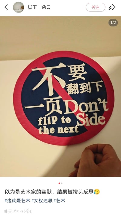 这是一张小红书平台的内容截图，图中展示了一个模仿交通禁止标志设计的圆形艺术标识：红圈蓝底搭配斜杠，用醒目的中英文写着「不要翻到下一页 Don’t flip to the next Side」。发布者原本以为这只是艺术家的趣味创作，没想到该标识背后关联着女权相关的深层议题，让自己被迫进行深度反思，配文「以为是艺术家的幽默，结果被按头反思😥」传递出无奈又疑惑的情绪。标识的设计自带逆反心理引导，容易让人产生「偏要翻」的想法，恰好契合其背后需要反思的主题。