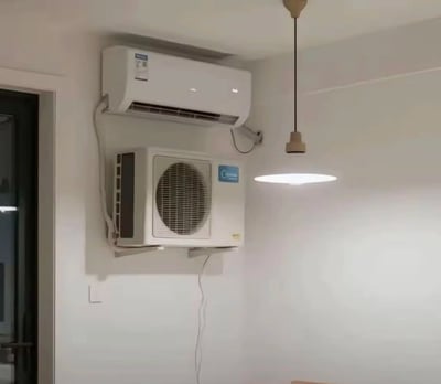 这张图片展示了一个房间的室内，墙上竟然同时装着空调的内机和外机，形成了离谱又令人发笑的场景。正常情况下空调外机应该装在室外，但是这里却被装到了屋子里，产生强烈的违和感，是工地/家庭装修失误的经典画面。
图中充满本末倒置的反讽意味，网友常用来调侃施工队或者房主的常识短板，也有“装反了”、“离谱他妈给离谱开门”等流行语内味儿。