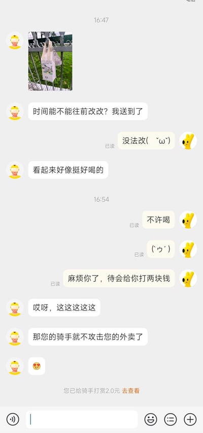 这是一张美团外卖骑手与顾客的聊天记录截图，对话过程轻松搞笑：骑手先发送了外卖挂在栏杆上的照片，请求顾客将送达时间往前修改，顾客表示无法修改；骑手随即调侃外卖看起来挺好喝，顾客连忙制止，接着提出要给骑手打赏2块钱，骑手用玩笑话回应“那您的骑手就不攻击您的外卖了”，最后界面显示顾客已完成2元打赏。整个对话充满生活化的趣味，氛围友好轻松。