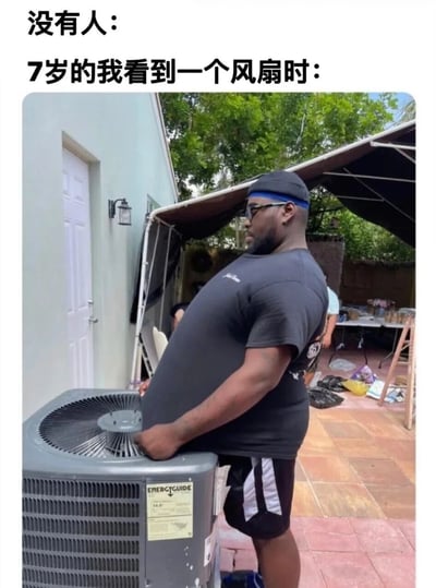 图片上方配有文字“没有人：7岁的我看到一个风扇时：”，下方是一张真人照片。照片中一名黑人男性戴着黑色帽子和墨镜，身穿黑色T恤与黑白条纹短裤，正双手扶着一台灰色的空调外机，身体前倾专注地观察着。通过夸张的对比手法，幽默地表现出7岁孩子看到风扇时可能产生的过度好奇或认真研究的可爱反应。