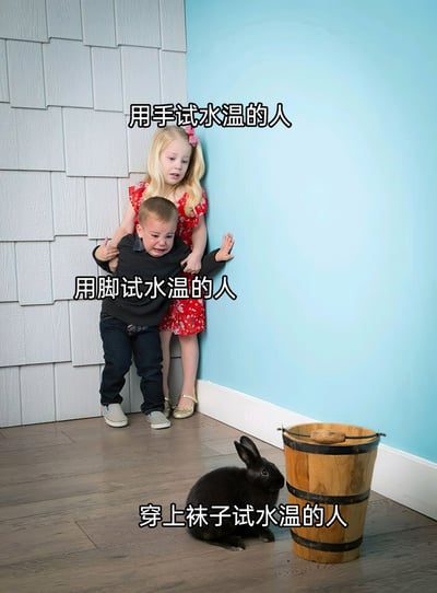 这是一张趣味梗图，通过不同角色的状态来调侃三种试水温方式的体验差异：上方的小女孩表情惊讶，对应“用手试水温的人”，手对温度的感知相对温和，反应较小；中间的小男孩大哭不止，对应“用脚试水温的人”，脚部对温度的敏感度更高，容易因水温不适产生激烈反应；下方的黑兔子平静地蹲在木桶旁，对应“穿上袜子试水温的人”，袜子隔绝了温度，几乎无法感知水温变化，状态毫无波澜。整幅图用生动的人物和动物状态反差，幽默地还原了生活中试水温的不同体验。