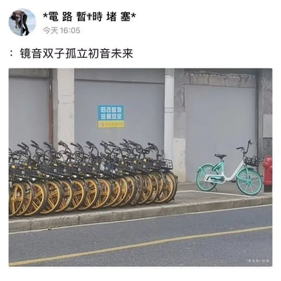 这是一张微信朋友圈的截图内容，发布者于16:05发布了实拍的城市路边共享单车场景：画面左侧是一排整齐聚集停放的黑黄配色共享单车，右侧则单独停着一辆青白色共享单车，两者形成鲜明的聚集与孤立的视觉对比。发布者配文“镜音双子孤立初音未来”，将成群的黑黄共享单车对应VOCALOID中的镜音双子（作为群体存在），单独的青白色共享单车对应初音未来，以此玩梗，用生活化的场景来贴合虚拟歌手相关的趣味联想，满足粉丝圈层的趣味表达。