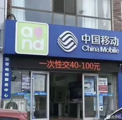 一张中国移动营业厅的实拍照片，门店上方有明显的中国移动标志和中英文名称。门店门口的LED显示屏上滚动显示着"一次性交40-100元"的字样。

该标语存在明显的双关语问题：表面上应是指"一次性缴费40-100元"，但"一次性交"的表述在中文语境中容易让人联想到不雅含义，形成了低俗的谐音梗效果。