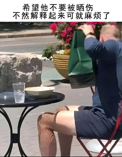 图片中一名男子坐在户外咖啡馆的椅子上，穿着蓝色上衣和深色短裤，但引人注目的是他腿上穿着渔网袜。他正用一个绿色的袋子罩在头上，似乎在遮挡阳光。图片上方配有文字：'希望他不要被晒伤 不然解释起来可就麻烦了'，暗示如果他被晒伤，别人可能会注意到他穿渔网袜的特殊穿搭，从而需要解释这个不寻常的选择。