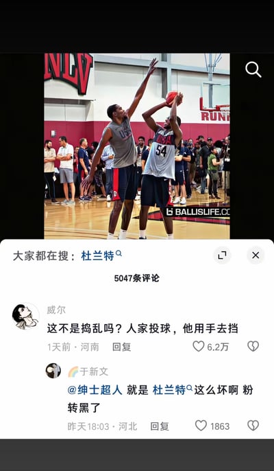 这是一张篮球训练场景的照片，画面中两名球员正在比赛，其中一名球员正在出手投篮，另一名防守球员高举手臂试图干扰投篮。该图片配有网络评论区截图，热评调侃杜兰特“打球犯规”，称其在防守时用手去挡对方投篮，并戏谑这种行为属于“搅乱局势”。下方有网友跟风玩梗，表示“粉转黑”（由粉丝转为黑粉）。整体氛围轻松幽默，主要聚焦于恶搞杜兰特的防守行为，将其放大为网络梗。没有包含谐音梗或暗示，但带有一定的调侃意味。
