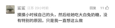 这是一张社交媒体评论截图，截图展示了来自江苏、昵称为“鲨鲨”的用户发布的一条评论，发布时间为23小时前，该评论获得了11个点赞，还设有回复按钮。评论内容为“摸摸小时候自己的头，然后给她吃大白兔奶糖，没有特别的原因，只是我一直想这么做”，文字充满了对童年自己的温柔与怜惜，用大白兔奶糖这个极具童年代表性的物品，传递出一种治愈感，是对过去的自己的隔空慰藉。用户的头像是一张表情呆萌的鲨鱼图片，整体风格温暖治愈。