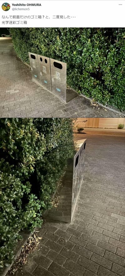 这是一组上下分栏的实拍对比图，展示了日本街头一个极具创意的分类垃圾桶。从第一张的正面视角观察，这个垃圾桶看起来仿佛只有正面的金属面板，像是悬浮在路边的“平面垃圾桶”，让人产生“为什么只有前面的垃圾桶？”的疑惑；切换到第二张的侧面视角后，谜底揭晓：垃圾桶的侧面采用了镜面材质，完美反射出旁边的绿植与地面环境，从而制造出“只有正面存在”的视觉错位效果，也就是推文里所说的“光学迷彩垃圾桶”，利用镜面反射打造出趣味十足的视觉欺骗。