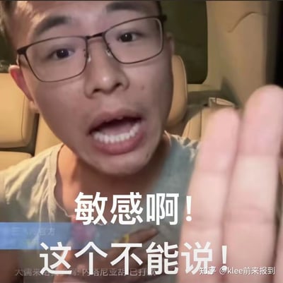 这是一张由直播画面截图制作的表情包，图中戴眼镜的男子坐在车内，表情激动，嘴巴大张，伸出手掌对着镜头，搭配醒目的白色配文“敏感啊！这个不能说！”，用来表达遇到敏感话题、不方便谈论的内容时，那种急切又无奈的状态，常被网友用来调侃需要避谈敏感内容的场景。