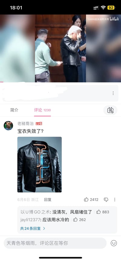这是一张B站视频页面的手机竖屏截图，顶部视频画面中一名穿黑色皮夹克的白发男子正抬手擦汗，看起来在炎热天气里穿着过厚十分燥热。下方切换到评论区，用户“老猪乔治”发布了一张经过创意修改的黑色皮夹克图，这件皮夹克内部加装了电脑水冷散热用的铜管和散热风扇，配文“宝衣失效了？”，调侃视频里的男子仿佛穿了内置散热的特殊衣服现在却失去了降温效果。该评论下还有其他网友跟风玩电脑硬件相关的梗，回复称“没清灰，风扇堵住了”“应该用水冷的”，整体内容搞笑诙谐，是将日常场景和数码领域梗结合的网络笑点内容。