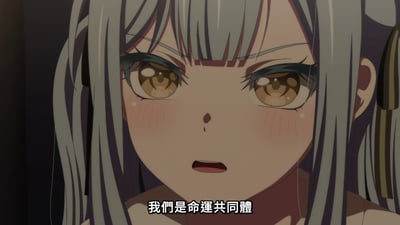 图片为动画《MyGO!》中的场景截图，展示了一位有着灰色长发、棕色眼眸的女性角色。角色脸颊泛红，眼角含着泪珠，眼神中带着激动与坚定，正说出字幕内容“我们是命运共同体”。画面聚焦于角色面部特写，背景较暗，突出角色的情绪表达。