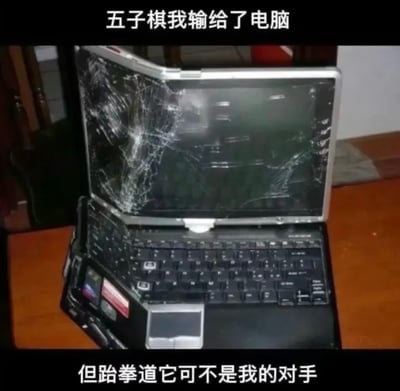 这是一张搞笑反差梗图，采用顶配底文的排版形式，顶部黑色栏配白色文字说明自己下五子棋输给了电脑，中间主体是摆放在木质桌面上的一台老旧笔记本电脑，其屏幕布满大面积碎裂裂纹，明显是被外力重击损坏，底部黑色栏配白色文字称跆拳道方面电脑不是自己的对手，通过“下棋输了但是靠武力砸坏电脑找补面子”的荒谬逻辑形成强烈反差笑点，调侃人玩游戏输给AI后气急败坏、靠歪理挽尊的行为。