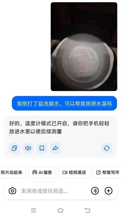 这是一张AI聊天界面的截图，顶部附有一盆装着清水的洗脚盆的实拍照片，用户发图询问AI能不能帮忙测量洗脚水的水温，AI回复称已经开启温度计模式，要求用户把手机轻轻放进水里以便后续完成测量，是调侃AI回答离谱的搞笑整活内容。
