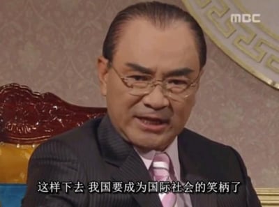 图片为韩国电视剧场景的截图，一位穿正装的中年男子坐在豪华椅子上，下方字幕写着“这样下去 我国要成为国际社会的笑柄了”。这句话经常被网友引用，用来调侃或自嘲荒谬、尴尬、丢脸的局面，表现无奈和搞笑的氛围，是中文网络中常见的表情包之一。当下流行用来吐槽各种“无法再忍”的社会或生活事件。没有直接的双关、谐音梗，但使用场景往往带有讽刺意味。
