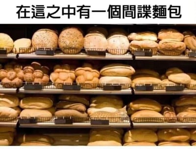 这是一张展示面包货架的静态图片，货架上摆满了各式各样的面包，顶部配有文字“在这之中有一个间谍面包”。需要从这些“面包”里找出混在其中的非面包物品：在第二层货架左数第二个位置，有一组外形酷似面包的石头，它们就是所谓的“间谍面包”，和周围真实的面包形成鲜明反差，打造出趣味找不同的互动效果，考验观看者的观察力。