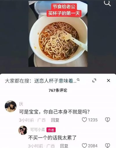 这张图是社交媒体平台的内容截图，上半部分展示了一张实拍图，白色容器内盛放着泡好的方便面，容器外形极易被误认为是马桶，上方配红色文字“节食给老公买杯子的第一天”；下半部分为该内容的评论区，顶部显示搜索提示“大家都在搜：送恋人杯子意味着...”，共有767条评论，第一条评论来自用户“厌”，内容为“可是宝宝，你自己本身不就是吗？”，获1235个点赞，发布者“可可小柔”回复该评论称“不买一个的话我太累了”，获2084个点赞，内容结合视觉错位与谐音梗，营造出搞笑的反差效果。