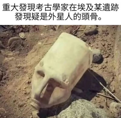 图片上方配有文字"重大發現考古學家在埃及某遺跡發現疑是外星人的頭骨。"，下方是一张在沙土中放置着一个白色塑料容器的照片，该容器被刻意摆放成类似头骨的样子，制造出考古发现的假象。这是一个通过将现代物品伪造成考古发现来制造幽默效果的梗图，利用了视觉误导的手法。