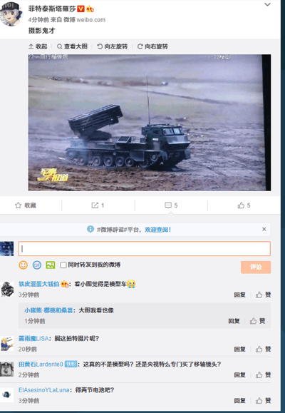 这是一张微博平台的截图，博主“菲特泰斯塔羅莎”发布了一张截取自央视《军事报道》的画面，画面中是一辆履带式火箭炮发射车，但由于拍摄的视觉效果，该装备看起来酷似玩具模型。博主配文“摄影鬼才”，以此调侃该画面的奇特视觉效果。评论区的网友们纷纷跟风玩梗，留言调侃该装备像模型车，猜测是不是用了移轴镜头，甚至戏称需要装两节电池，还有网友调侃像是在拍特摄片，整体氛围充满趣味，都是针对画面的视觉错觉展开的玩笑。