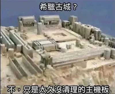 图片展示了一块布满灰尘的主板特写，其元件和灰尘堆积的纹理意外酷似古希腊古城的建筑布局。图片上方配有文字“希腊古城？”，下方则揭晓“不，只是太久没清理的主机板”，通过视觉相似性制造幽默反差效果，调侃电脑主机长期不清理积灰的状况。