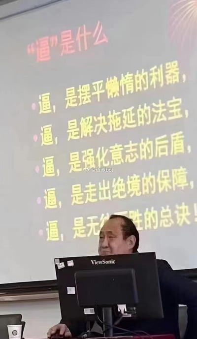 这是一张课堂实拍的静态图，一位中年男性授课老师坐在优派（ViewSonic）品牌的电脑后方，身后的投影屏幕上展示着以“‘逼’是什么”为核心标题的励志内容，用五条直白有力的语句，将“逼自己”解读为摆平懒惰、解决拖延、强化意志、走出绝境、无往不胜的关键，接地气的表述搭配老师平和带笑的神态，让这段励志内容显得真实且有说服力，传递出“自我逼迫是成长突破的动力”的理念。