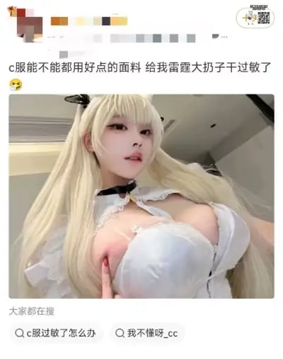 这是一张国内社交平台的用户动态截图，发布者为一名女性cosplay爱好者，她吐槽cosplay所用的服装（C服）面料质量差，导致自己胸部皮肤过敏，配文使用谐音梗“雷霆大扔子”代指胸部，用词夸张搞笑。配图是该coser穿着白色C服的自拍，她留着浅金色双马尾假发，手指指向自己胸口靠近C服边缘处泛红的过敏皮肤，整体内容充满反差笑点。截图底部还显示有平台的相关搜索推荐词条：“c服过敏了怎么办”和“我不懂呀_cc”，右上角带有带二维码的平台水印。