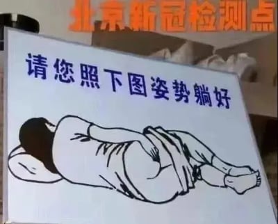 这是一张网友恶搞的P图，画面上方标注“北京新冠检测点”，下方的提示牌写着“请您照下图姿势躺好”，但配图却是一个侧卧、掀开衣物露出臀部的类似分娩的姿势，和新冠核酸检测的实际姿势完全不符，通过这种强烈的反差感制造搞笑效果，属于对新冠检测场景的趣味调侃，没有双关、谐音梗等内容。