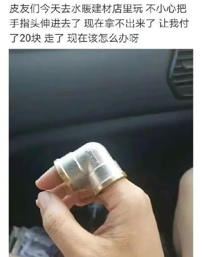 图片上方为文字描述，内容是用户向“皮友”求助：在水暖建材店玩耍时，手指不慎伸进黄铜弯头管道配件中无法取出，被店家要求支付20元后离开，现寻求解决办法。图片下方为实拍照片，显示一只手的手指上牢牢套着一个黄铜材质的90度弯头管道配件，背景模糊，推测为室内环境。整体内容呈现生活中的意外搞笑场景，带有求助性质。
