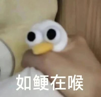 图片中是一只白色小鸭子毛绒玩具，有着超大的黑色圆眼睛和黄色嘴巴，被一只手指轻轻捏住。背景是木质纹理和淡黄色物体。图片底部有白色文字“如鲠在喉”。小鸭子呆萌的表情配合文字，生动展现出一种想说又说不出来的尴尬或难受情绪，常用来表达内心有话憋着的无奈状态。