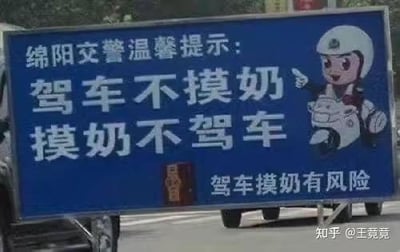 图片展示了一块蓝色的绵阳交警温馨提示牌，牌面主体文字为白色大号字体的“驾车不摸奶，摸奶不驾车”，上方有“绵阳交警温馨提示：”字样，下方小字补充“驾车摸奶有风险”。右侧配有一个卡通交警形象，该形象头戴白色头盔，骑在摩托车上，右手伸出指向标语内容，表情严肃。图片右下角有“知乎@王竞竞”的水印标识。此标语因语言直白粗俗引发争议，旨在通过夸张方式提醒驾驶员专注驾驶，避免分心行为。