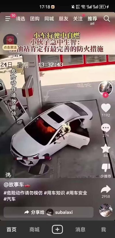 这是一段抖音平台的短视频截图，画面为加油站监控视角，显示一辆白色轿车在行驶中车内突发自燃，司机焦急地将车辆开进加油站，车门打开，车内有明火冒出。配文调侃司机“急中生智认为加油站有最完善的防火措施”，同时画面多处标注“危险动作请勿模仿”的警示语，视频账号“故事车”通过该真实事件科普用车安全知识，提醒车主不要效仿此类危险行为。