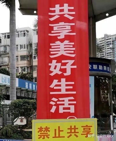 现场拍到一组矛盾的标语：红色大幅宣传语写着“共享美好生活”，而正下方却有一个醒目的黄色标牌写着“禁止共享”，形成极具反差感的画面。这种‘自打脸’式的文字冲突非常容易引发网友的吐槽和调侃。画面没有人物，仅有城市环境、宣传语和提示牌。此梗常用于形容行动和口号完全背道而驰的尴尬场景。

**梗点说明：**上下两块宣传语字面矛盾，带有明显反讽和自嘲意味。