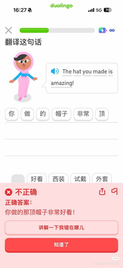 这是一张多邻国（Duolingo）语言学习APP的竖屏界面截图，展示了一道英译汉翻译题：要求翻译英文句子“The hat you made is amazing!”。用户选用了网络热词“顶”来组成答案“你做的帽子非常顶”，被系统判定为不正确，系统给出的标准正确答案是“你做的那顶帽子非常好看！”。“顶”作为网络用语虽能表达“很棒”的含义，但不符合翻译题的规范表述，形成了日常网络用语和标准翻译之间的搞笑反差，充满趣味性。