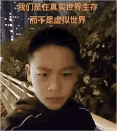这是一张真人照片制作的梗图，图中是一位表情严肃、眼神坚定的男孩，背景是夜晚的户外场景，能看到树木和远处的城市灯光。图片上方配有醒目的黄色文字：“我们是在真实世界生存 而不是虚拟世界”，用直白的话语传递出反对过度沉浸虚拟世界的态度，整体氛围严肃且坚定，适合用来表达对沉迷虚拟事物的吐槽与对真实生活的强调。