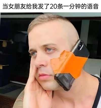图片上方有文字“当女朋友给我发了20条一分钟的语音”，下方是一个光头男子，他的右脸上固定着一个橙色的手机支架，支架上放着一部黑色手机，男子表情严肃，左手托着下巴，似乎在认真听手机里的语音内容。通过夸张的手机支架使用方式，幽默地表现出收到大量长语音消息时的无奈和需要长时间聆听的场景。