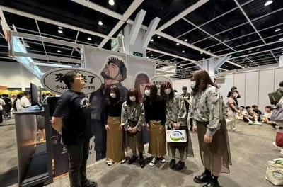 这张图片拍摄于一个大型展会现场（如动漫展/漫展），背景是展台和许多参展者。前景中的几个人都穿着极为相似的装扮（浅色印花上衣与浅褐色半身纱裙），其中包括几位戴口罩的女生和一位同样装扮、身型较大的男性，场面显得颇为有趣。这样的相似装扮容易引发“复制粘贴”或“双胞胎”梗，给人幽默感和复读机既视感。

图中的展台布景板上写着“来了就对了，去G2XX逛一下吧”，是一种吸引参观者去指定展位的宣传方式。

没有明显的双关或谐音梗，但视觉效果带有反差和戏谑意味。