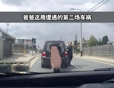 行车记录仪视角下的道路场景，前方一辆黑色面包车的后备箱敞开，一块棕色木板从车尾伸出。一名男子正行走在面包车旁，似乎在处理突发状况。图片上方配有文字“爸爸这周遭遇的第二场车祸”，暗示这是本周内发生的第二次意外，整体氛围带有幽默调侃的意味。