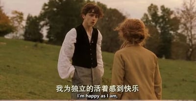 这是一张2019年电影《小妇人》的视频截图，画面呈现了户外的草地场景，背景是染上秋意的树木，天色柔和。画面左侧是提莫西·查拉梅饰演的劳里，他身着白色宽松衬衫搭配黑色马甲与灰色长裤，双手插在裤袋中，正专注地看着对面的人，神情带着一丝复杂的怅然。画面右侧是西尔莎·罗南饰演的乔，她背对着镜头，头发被风吹得有些凌乱，穿着卡其色外套，正在表达自己的想法。画面下方配有中文字幕“我为独立的活着感到快乐”以及对应的英文台词“I'm happy as I am,”，传递出乔对于独立生活的坚定向往，不愿被传统的婚姻与女性角色束缚的态度。