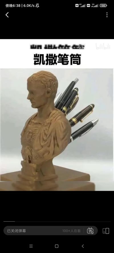 这是一款以罗马历史人物尤利乌斯·凯撒为原型设计的创意恶搞笔筒，将钢笔从凯撒半身雕像的背部插入，还原了凯撒遇刺身亡的历史典故，把办公文具收纳和历史梗结合，制造出荒诞搞笑的趣味效果。
玩梗说明：历史上凯撒被多人刺杀，背部中多刀，这款笔筒用钢笔模拟刺杀的刀具，调侃了这一历史事件。