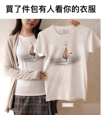 图片展示了一位女性手持并穿着一件设计独特的白色T恤。T恤上印有逼真的视觉错觉图案，看起来像是穿着者的胸部和内衣外露，创造出引人注目的效果。图片上方配有文字'买了件包有人看你的衣服'，幽默地表达了这件衣服的吸睛特性。