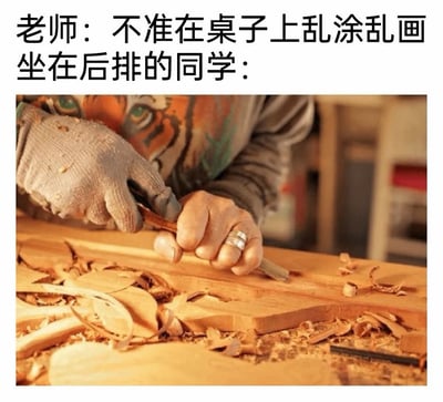 这张梗图采用图文混排的形式，上方文字为「老师：不准在桌子上乱涂乱画」和「坐在后排的同学：」，下方配图是一双手戴着一只防护手套，正用工具在木桌上进行雕刻操作，桌面散落着大量木屑。
通过夸张的反差感玩梗：老师禁止在桌上乱涂乱画，后排同学却用更“过分”的雕刻行为钻语言空子，制造出荒诞搞笑的效果，精准戳中校园生活里学生和老师之间的趣味互动场景。