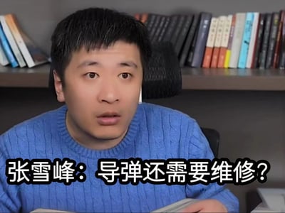 这是一张由视频截取制作的梗图，画面主体是知名志愿规划博主张雪峰，他身穿蓝色针织毛衣坐在办公椅上，身后是摆放了多本书籍的书架，脸上露出惊讶疑惑的神情，图片下方配有文字“张雪峰：导弹还需要维修？”，直观表现出对“导弹需要维修”这一信息的意外与不解。