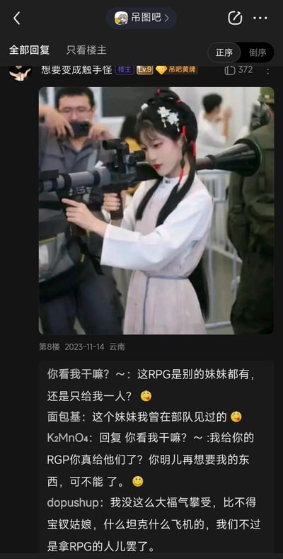 这是百度贴吧「吊图吧」的一则帖子，楼主发布了一张漫展现场的照片：一位身着汉服的少女手持RPG火箭筒，专注瞄准，古典服饰与硬核军事装备形成强烈反差。评论区用户模仿《红楼梦》中林黛玉与贾宝玉的经典试探对话句式，将对话中的物品替换为RPG、坦克、飞机等军事装备，用古典文学的委婉语气讨论硬核武器，制造出荒诞搞笑的反差感。
梗说明：改编自《红楼梦》中林黛玉试探贾宝玉的经典桥段，属于文体梗的二次创作，用跨次元的反差搭配经典文学句式，放大搞笑效果。