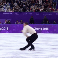 这是一段记录2018年平昌冬季奥林匹克运动会花样滑冰赛事的动态GIF，画面中一名男性花样滑冰运动员正在冰面上完成滑行动作，身体前倾、双腿弯曲，姿态专业且专注。背景可见赛场的观众席以及带有「PyeongChang 2018」字样的赛事标识，左上角还有NBC的媒体台标，完整呈现了冬奥会花样滑冰项目的赛场精彩瞬间。