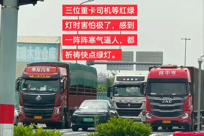 这张图片拍摄于路口，画面中有三辆大型卡车并排行驶，夹在卡车中间的是一辆普通小轿车。配文写着：“三位重卡司机等红绿灯时害怕极了，感到一阵阵寒气逼人，都祈祷快点绿灯。” 文字表达出小车司机被卡车包围时的紧张与恐惧，突出环境的压迫感和无力感。画风真实，极具代入感，非常适合用于描述“被大环境压制”、“弱小无助”等网络语境。

未发现明显的双关用法，整体以真实场景营造压抑气氛为主。