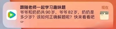 这是一张短视频平台的截图，画面主体是橙色背景上的白色文字，内容为一道趣味数学题：'爷爷和奶奶共90岁，爷爷82岁，奶奶是多少岁？该如何正确解题呢？快来看看吧'。左侧有一个彩色三角形的播放按钮图标，右侧有一个小方框，里面写着'现在'和部分重复的题目文字。图片整体风格简洁，旨在吸引用户点击观看视频内容。