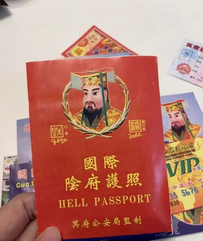 这是一组模仿现实证件、金融卡设计的创意祭祀用品，最突出的是红色封面的《国际阴府护照》，封面上绘制了严肃庄重的阴府帝王（阎王类）形象，标注“冥府公安局监制”，还配有“行长”“副行长”的签章与署名；周边还有冥通银行VIP卡等同类祭祀道具，整体复刻了现实生活中的证件、银行卡体系，以幽默贴近现代的形态，作为祭祀时焚烧给先人的民俗纸品，是传统冥币的创意延伸。