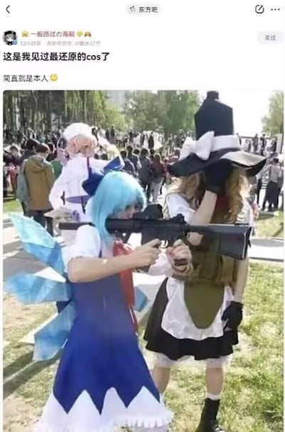 图片展示了动漫展上的几位cosplayers，其中一位蓝发coser手持步枪摆出射击姿势，另一位戴着大帽子的coser用手遮着脸，背景中还有其他参会者。配文称这是"最还原的cosplay，简直就是本人"，通过coser手持步枪的反差感制造幽默效果。