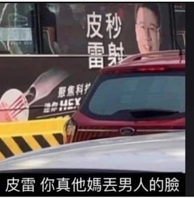 这是一张户外实景抓拍的静态图，背景是一块医美广告牌，上面印有“皮秒雷射”的大字、一位面带微笑的男性肖像，以及“聚焦科护 选择HEX”的宣传语。前景的红色汽车恰好挡住了广告牌上“秒”和“射”的部分，让原本的“皮秒雷射”看起来变成了“皮雷”。图片下方被加上了调侃性配文“皮雷 你真他媽丟男人的臉”，利用文字遮挡形成的谐音梗，制造出荒诞搞笑的调侃效果，属于典型的视觉错位类趣味梗图。