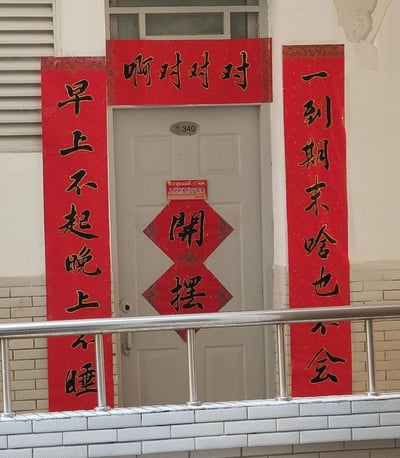 这是一张实拍的宿舍门口照片，门牌号为340，门上贴有“入党积极分子宿舍”的正式标识，同时张贴了一组充满大学生自嘲风格的春联：横批为“啊对对对”，上联是“一到期末啥也不会”，下联是“早上不起晚上不睡”，还有倒贴的“開摆”（开摆）斗方。正式标识与搞笑春联形成强烈反差，用幽默的口吻精准调侃了部分大学生颠倒的作息习惯和期末备考时的焦虑摆烂心态，充满校园生活的趣味感。