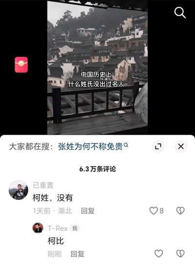 这是一张来自短视频平台的竖屏屏幕截图，视频画面为徽派风格的古村落景观，字幕提出问题“中国历史上什么姓氏没出过名人”，下方关联搜索词条为“张姓为何不称免贵”，评论区共有6.3万条评论。其中用户“已重置”留言称“柯姓，没有”，用户“T-Rex”则以“柯比”回复，利用谐音梗将美国篮球明星科比（Kobe）的名字谐音为“柯比”，以此玩梗式地反驳前者的观点，制造出趣味反差——用外国名人的谐音来回应中国历史姓氏名人的问题，属于网络社区里的趣味互动内容。